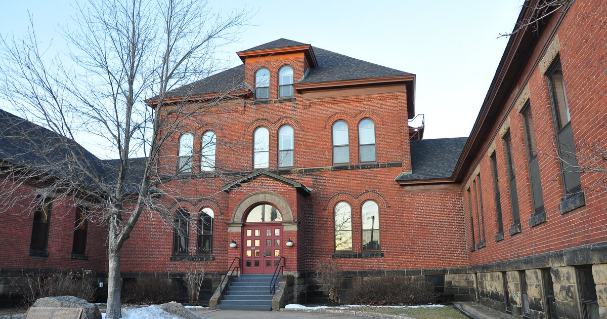 Brick building in Moncton, New Brunswick in winter with snow on the ground and bare trees